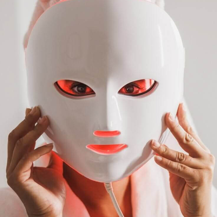 Woman holding Evara Beauty LumiGlow LED face mask